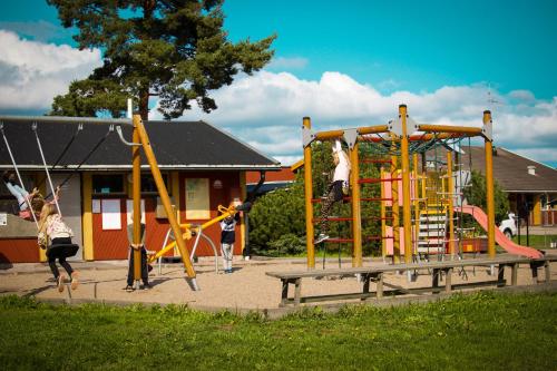 eine Gruppe von Kindern, die auf einem Spielplatz spielen in der Unterkunft Årsunda Strandbad Sjösunda vandrarhem in Årsunda