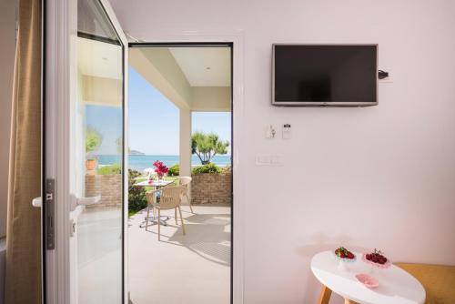 a room with a sliding glass door with a view of the ocean at Hermes Beach Front in Stalos