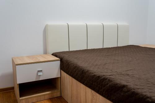 ein Schlafzimmer mit einem Bett und einem Nachttisch daneben in der Unterkunft SinaiaMountainView - Vista in Sinaia