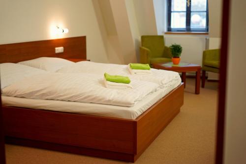 a bedroom with a bed with green pillows on it at Zámecký Penzion in Valašské Meziříčí