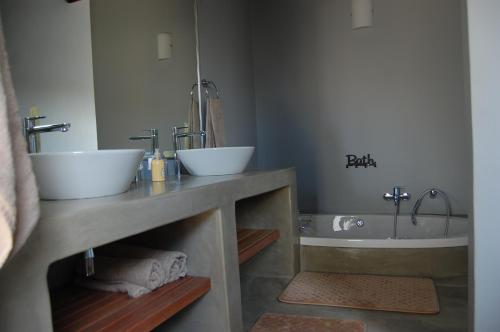 a bathroom with two sinks and a tub at Ngalas Rest 101 in Hectorspruit