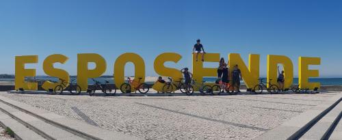 a group of people on bikes in front of a large sign at InnEsposende Sports Hostel in Esposende