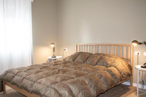 a bedroom with a large bed with a wooden headboard at Trilocale in centro a Chiesa Valmalenco in Chiesa in Valmalenco