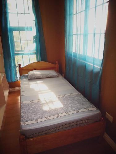 a twin bed in a room with a window at Koinonia Retreat CenteR in Baguio