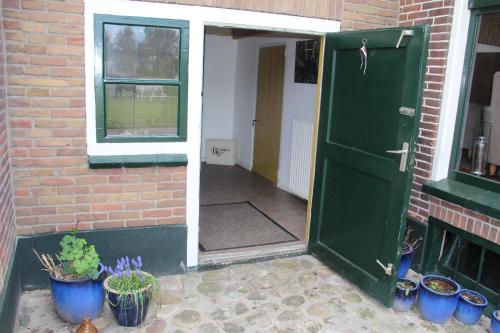 an open door to a brick building with potted plants at B&B In de Backerije in Zuidwolde