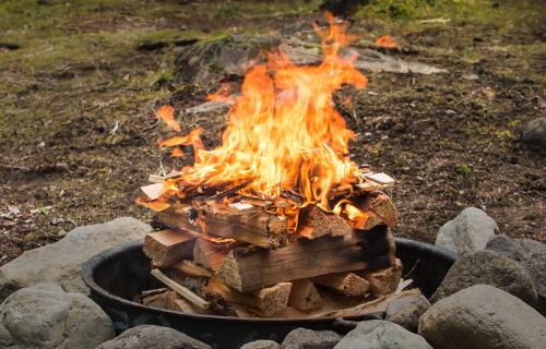 a fire in a pot with logs in it at Edgestay in Mudigere