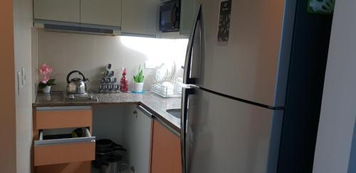 a kitchen with a stainless steel refrigerator in a kitchen at Mactan Newtown Ocean View 360 Degree in Mactan