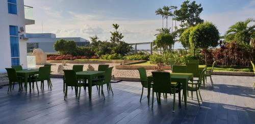 a group of green tables and chairs on a patio at Mactan Newtown Ocean View 360 Degree in Mactan