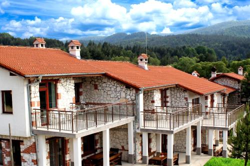 un groupe de maisons avec balcon et montagne dans l'établissement Къщи за гости Илиеви , Цигов Чарк, à Batak