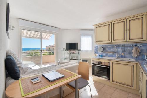 une cuisine et un salon avec un canapé et une table dans l'établissement La Belle Vue, à Sausset-les-Pins