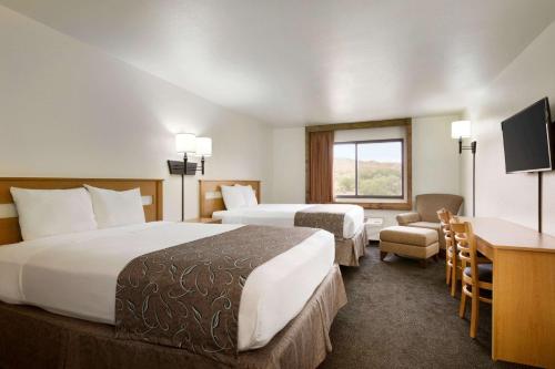 um quarto de hotel com duas camas e uma secretária em Travelodge by Wyndham Belen em Belen