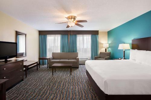 a hotel room with a large bed and a television at Baymont by Wyndham Evansville East in Evansville