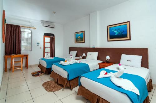 Tempat tidur dalam kamar di Hotel Coloma Galapagos