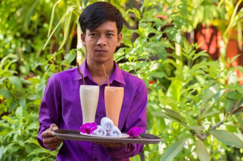 a man holding a tray with a dessert on it at Bou Savy Villa in Siem Reap