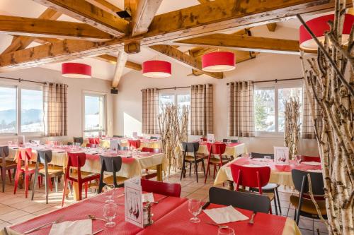 a dining room with red tables and chairs and windows at Azureva Bussang in Bussang