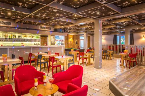 a restaurant with red chairs and tables and a bar at Azureva Bussang in Bussang