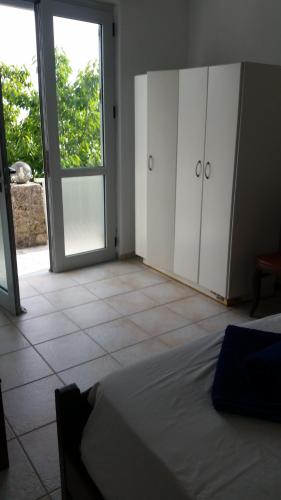 a bedroom with a bed and a sliding glass door at Dimitra Apartments K in Kommeno