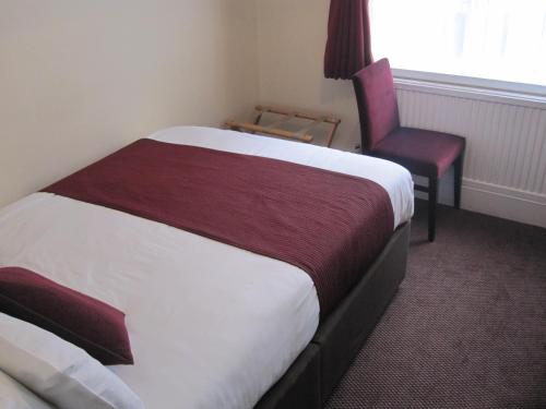 Habitación de hotel con cama y silla en Mabledon Court Hotel en Londres