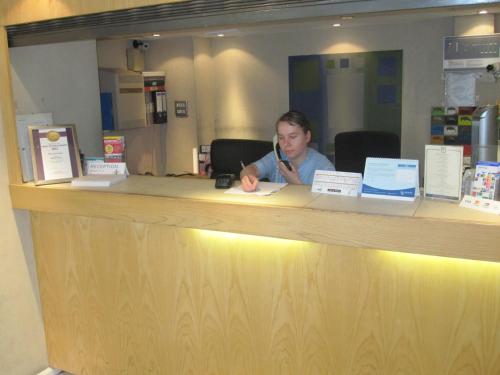 a woman sitting at a counter in front of a counter top at Mabledon Court Hotel in London