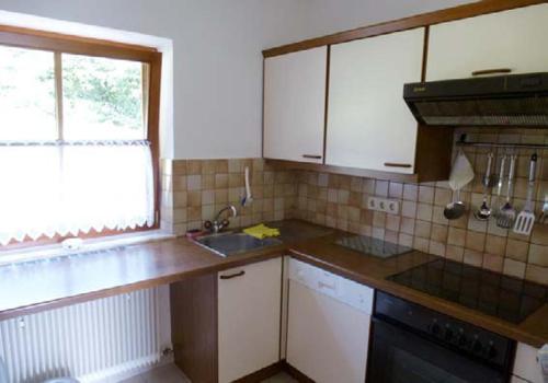eine kleine Küche mit einem Waschbecken und einem Fenster in der Unterkunft Haus Christiane in Pörtschach am Wörthersee