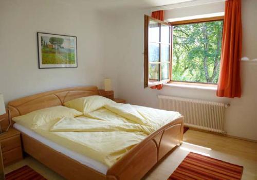 Bett in einem Schlafzimmer mit Fenster in der Unterkunft Haus Christiane in Pörtschach am Wörthersee