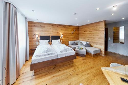 a bedroom with a large bed and a couch at Die Reichsstadt - Hotel Spa und Restaurant in Gengenbach