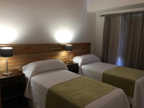 a hotel room with two beds and two lamps at Balcones al Nahuel II in San Carlos de Bariloche