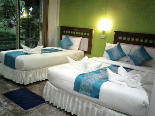a room with three beds with white birds on them at Lanta Long Beach Hostel in Ko Lanta