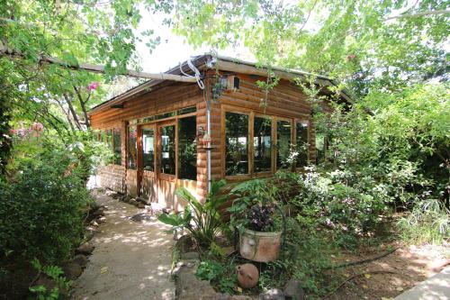 a small wooden cabin in the middle of a garden at Vitrage Holiday Village and Spa in Bet Hillel
