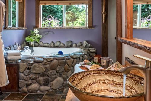 y baño con bañera de piedra y lavamanos. en Carson Ridge Luxury Cabins en Carson
