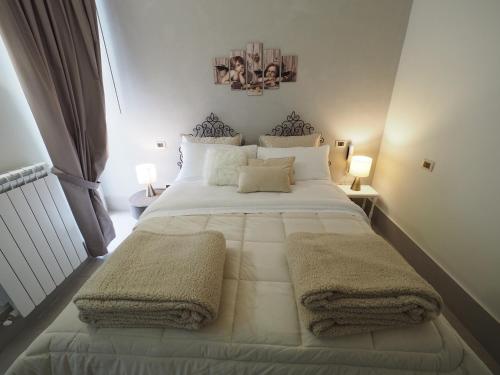 a bed room with a white bedspread and pillows at Relais Palazzo Duomo B&B in Nola