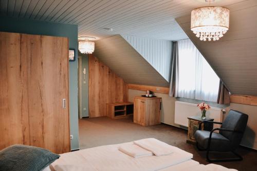 sypialnia z łóżkiem, krzesłem i schodami w obiekcie Hotel U Hradu w mieście Mladá Boleslav