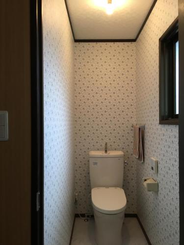a bathroom with a white toilet in a room at オソレイユ in Okayama