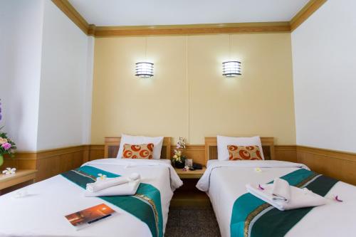 duas camas num quarto de hotel com lençóis brancos em Boom Forest Hotel em Hat Yai
