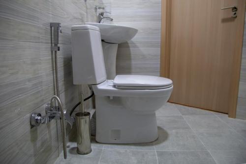 a bathroom with a white toilet and a sink at Family Hotel Triston in Tbilisi City
