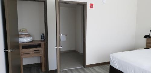 a bedroom with a door open to a room with a bed at Wyndham Garden Ft Lauderdale Airport & Cruise Port in Dania Beach