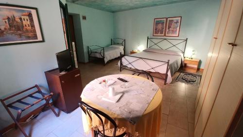 a room with two beds and a table and a television at Hotel Centrale in Viterbo