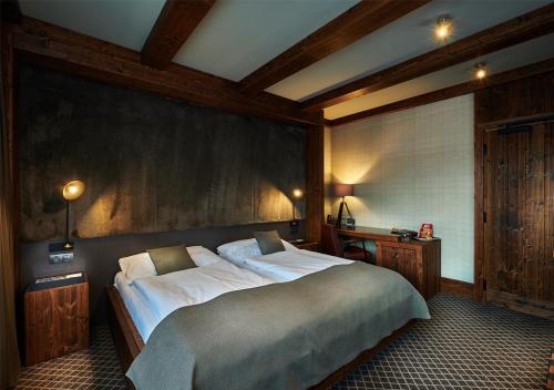a bedroom with a large bed and a wooden wall at Hotel Pošta in Demanovska Dolina