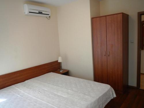 1 dormitorio con 1 cama y armario de madera en Apartment in Elit 3 Apartcomplex, en Sunny Beach