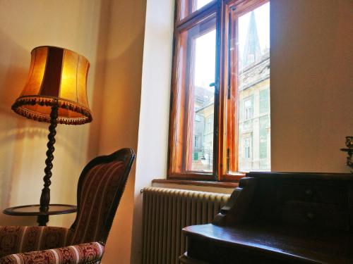 a lamp sitting next to a chair next to a window at Zur Krone in Sibiu