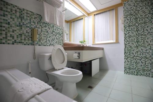 a bathroom with a toilet and a sink and a shower at Tiara Oriental Hotel in Manila