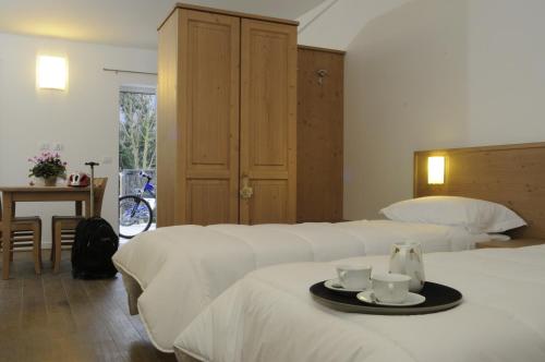 Habitación de hotel con 2 camas y bandeja con 2 tazas en Agriturismo Monte Del Re, en San Pietro al Natisone