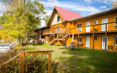 a large wooden building with a red roof at Curriers Lakeview Lodge in Rice Lake