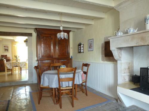 a dining room with a table and chairs and a fireplace at LA MAISON BLEUE in Saint-Gelais