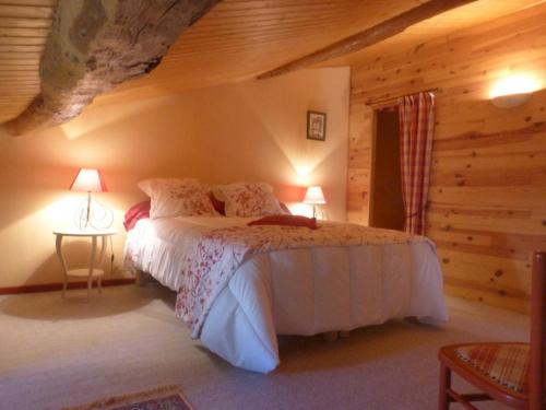 a bedroom with a bed in a log cabin at LA MAISON BLEUE in Saint-Gelais