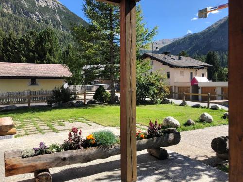 una croce di legno con fiori in un cortile di Chesa Aurora - La Punt a La Punt-Chamues-ch