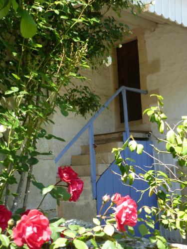 a blue stairway with red roses in front of a door at LA MAISON BLEUE in Saint-Gelais