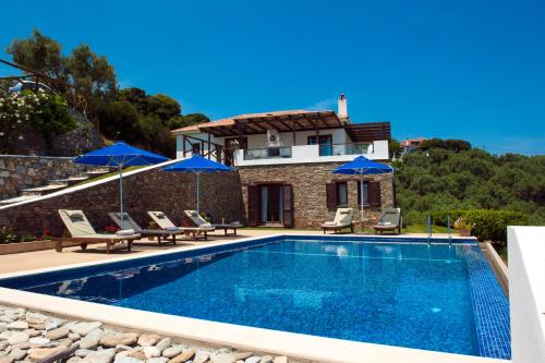 a villa with a swimming pool and a house at villa iliana in Skiathos