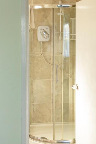 una ducha con puerta de cristal en un baño en Leeward House B&B, en Gosport