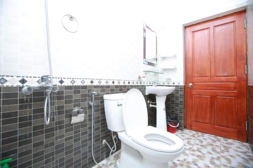 a bathroom with a toilet and a red door at Cozy Son Hotel in Ninh Binh